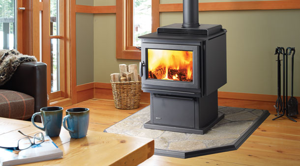 Regency Pro-Series F3500 Large Wood Stove lit in living room with two blue coffee cups in foreground