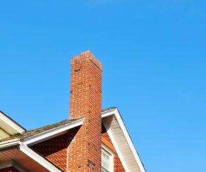 chimney with red house against blue sky chimney with red house against blue sky