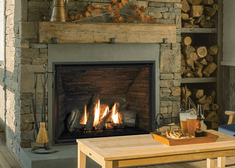 Valor H6 Gas Fireplace lit in living room with stone surround and wood mantle
