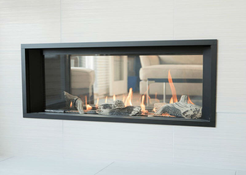 Valor LinearL1 See-Thru Gas Fireplace set into a rock and shale wall that sees into living room