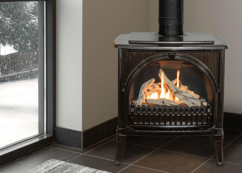 Valor Madrona Stove set in corner on tile floor with snowy view of outside to the left