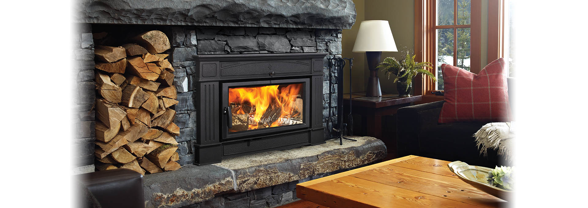 Hampton Hi500 Wood Insert Hampton Hi500 Wood Insert with dark natural cut stone surround and wood pile stacked next to it