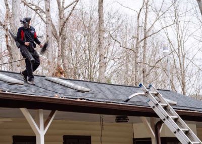 Technician on roof walking toward ladder after completing sweep service
