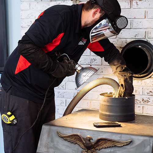 Technician wearing a mask inspecting chimney cap