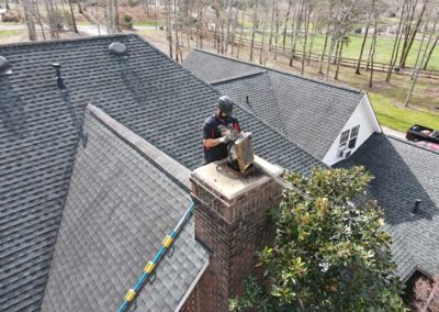 Technician removing and cleaning chimney cap