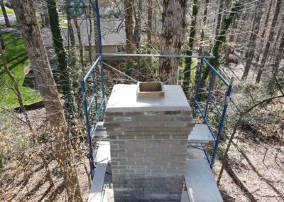 Chimney restoration and repair of masonry in progress on beige chimney
