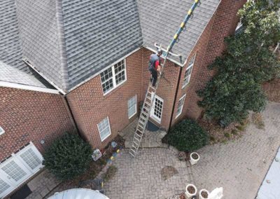 Aerial view of technician on ladder prepping for chimney restoration