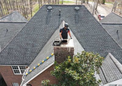 Technician standing next to chimney with cap removed