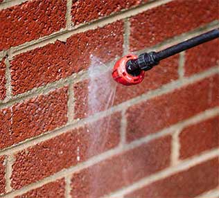 Close up of water repellent treatment being sprayed on to chimney masonry