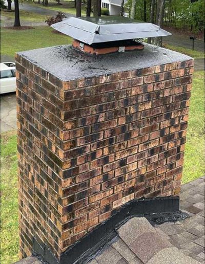 Dirty and cracked chimney on roof with damaged chimney cap before repairs