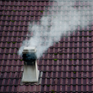 smoking white chimney with black soot stains
