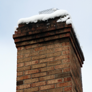 masonry chimney with snow sitting on top