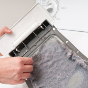 someone peeling the lint off of a dryer lint trap