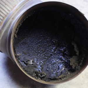 black, tar-y creosote in a metal pipe