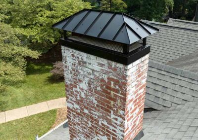 Brick chimney with a new black chimney cap
