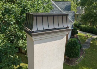 Brick chimney with a new gray chimney cap