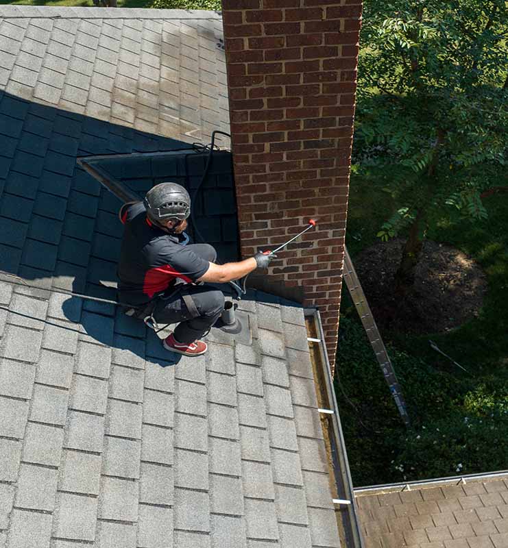 Crew spraying water repellent onto chimney 