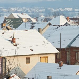a distant view of many houses with chimneys covered in snow