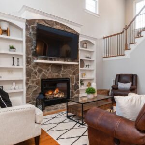 stone fireplace in a furnished living room with a tv mounted above it