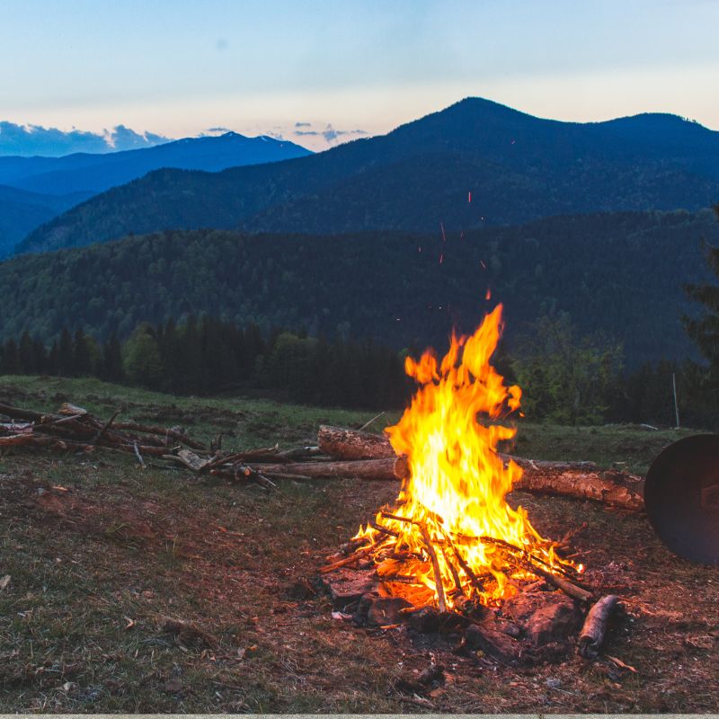 stock photo of campfire an outdoor fire with mountains in the background