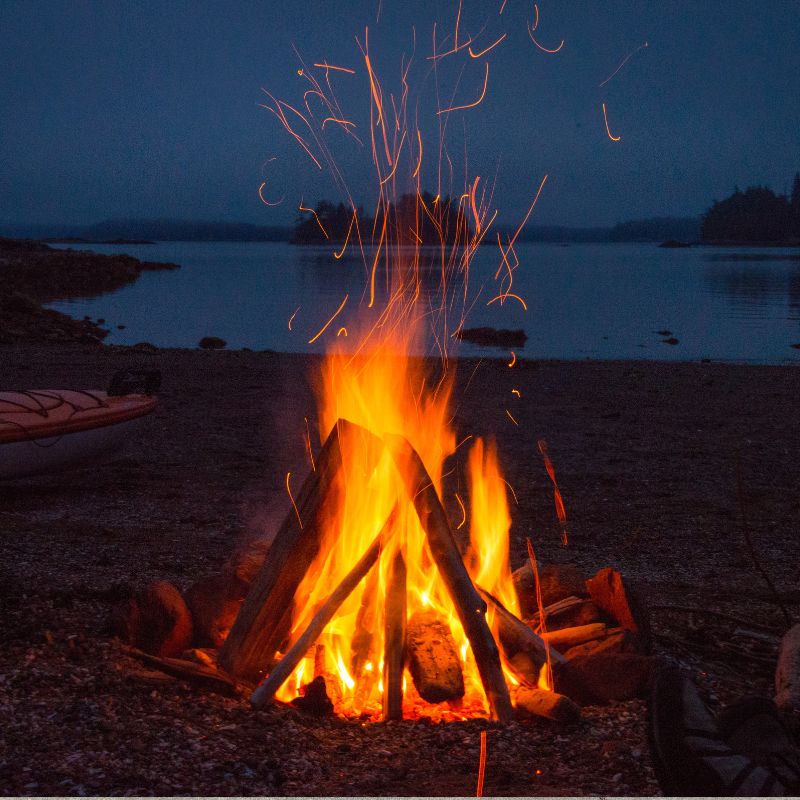 stock photo of campfire an outdoor fire with a lake in the background