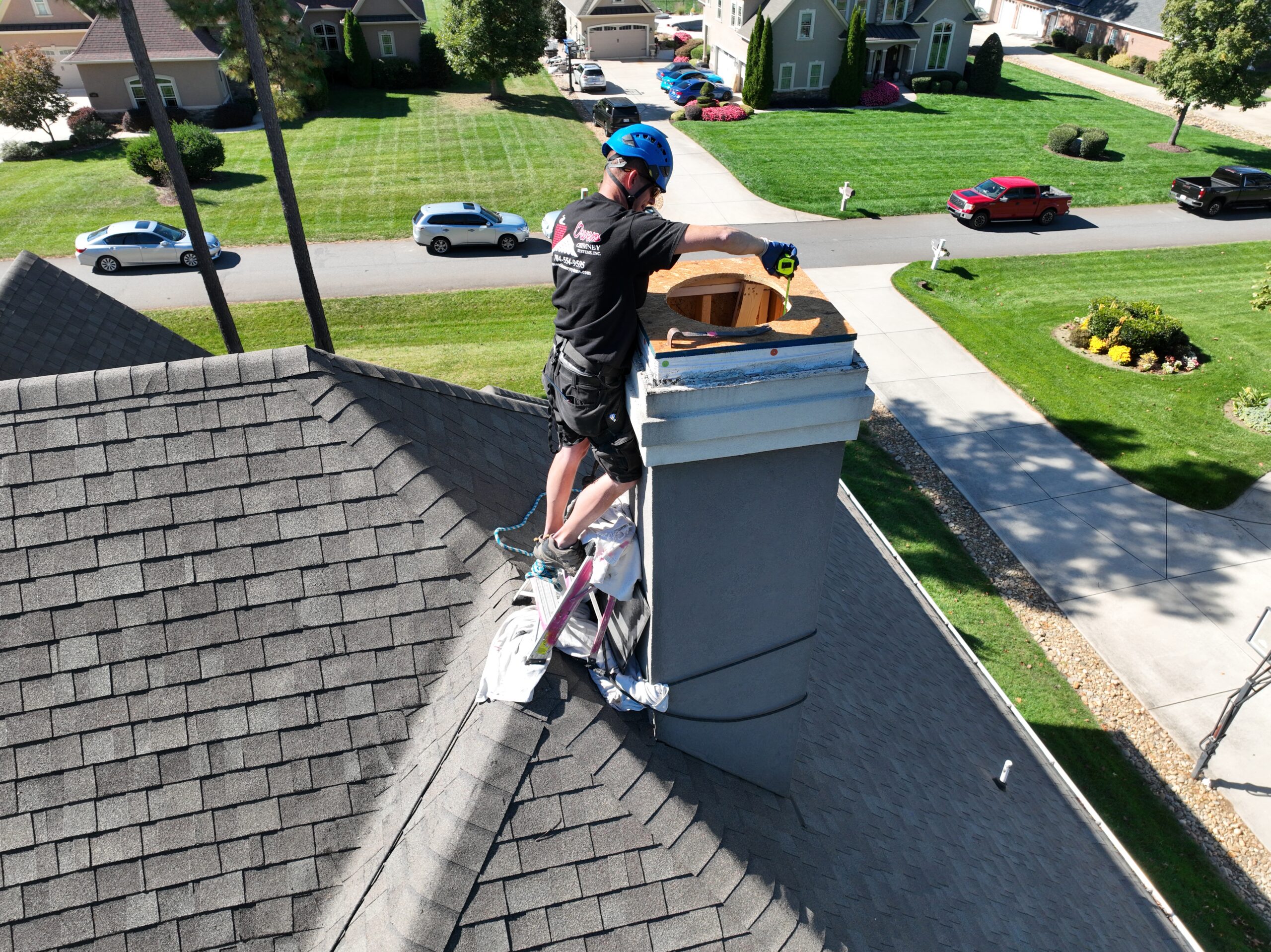 A chimney technician from Owens Chimney Systems working on a chimney.